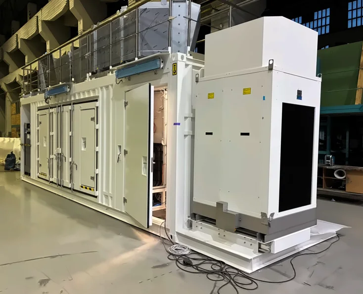 Finished white steel container enclosure with side cooling unit, inside a production hall
